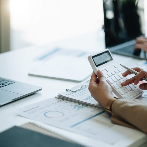businesswoman accountant hand working on calculator to calculate financial data report, accountancy